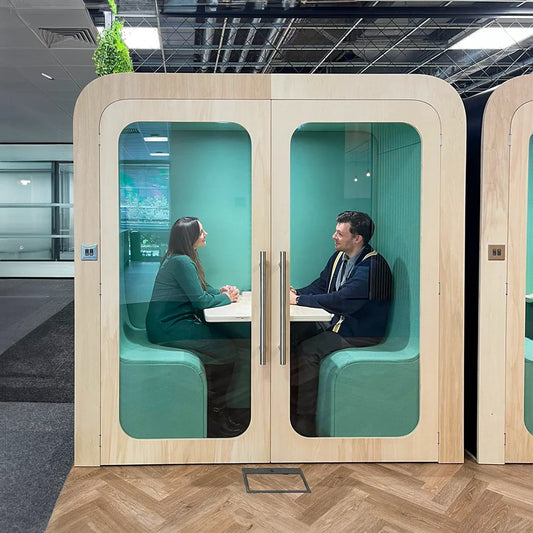 Two people having a private meeting inside a double Dapapod office pod