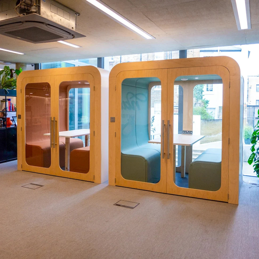 Two Dapapod office meeting pods with pink and blue interiors