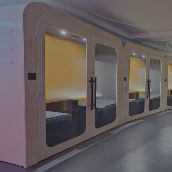 A row of Dapapod booths with yellow interiors in a coworking space