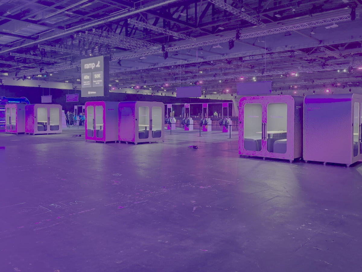 Multiple Dapapod booths installed across an exhibition hall under purple lighting