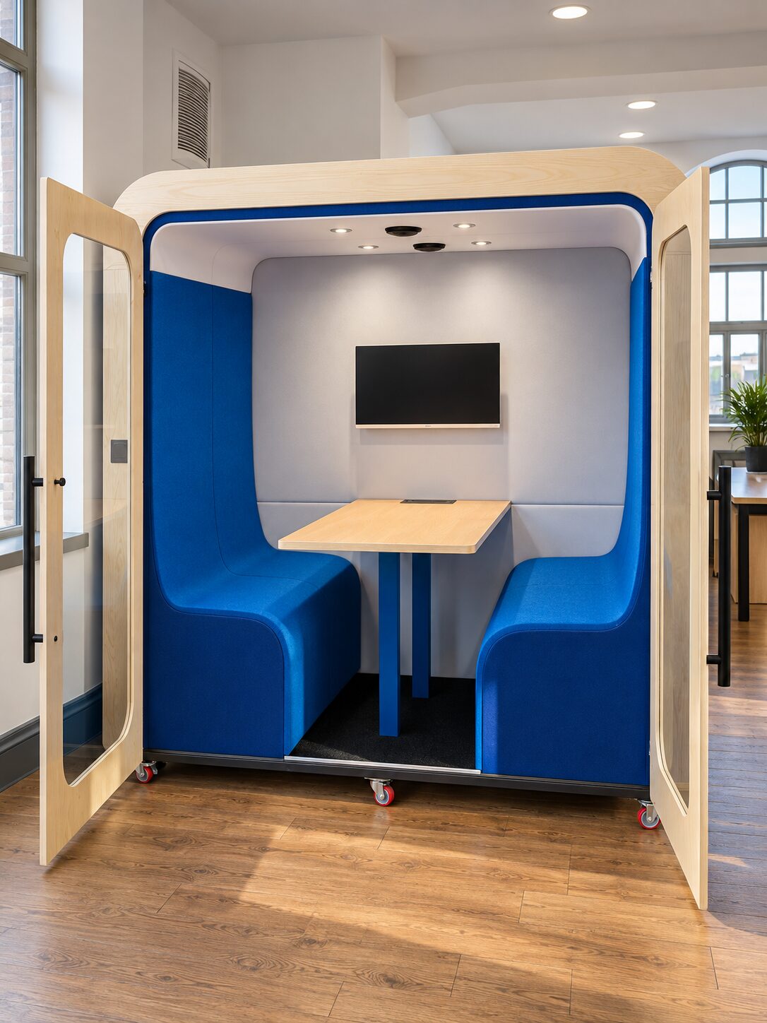 Dapapod four-person booth with blue wool interior, wall-mounted screen and castors