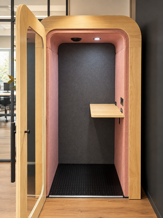 Dapapod Standing Office Pod with the door open, showing a pink and charcoal interior and a standing-height shelf